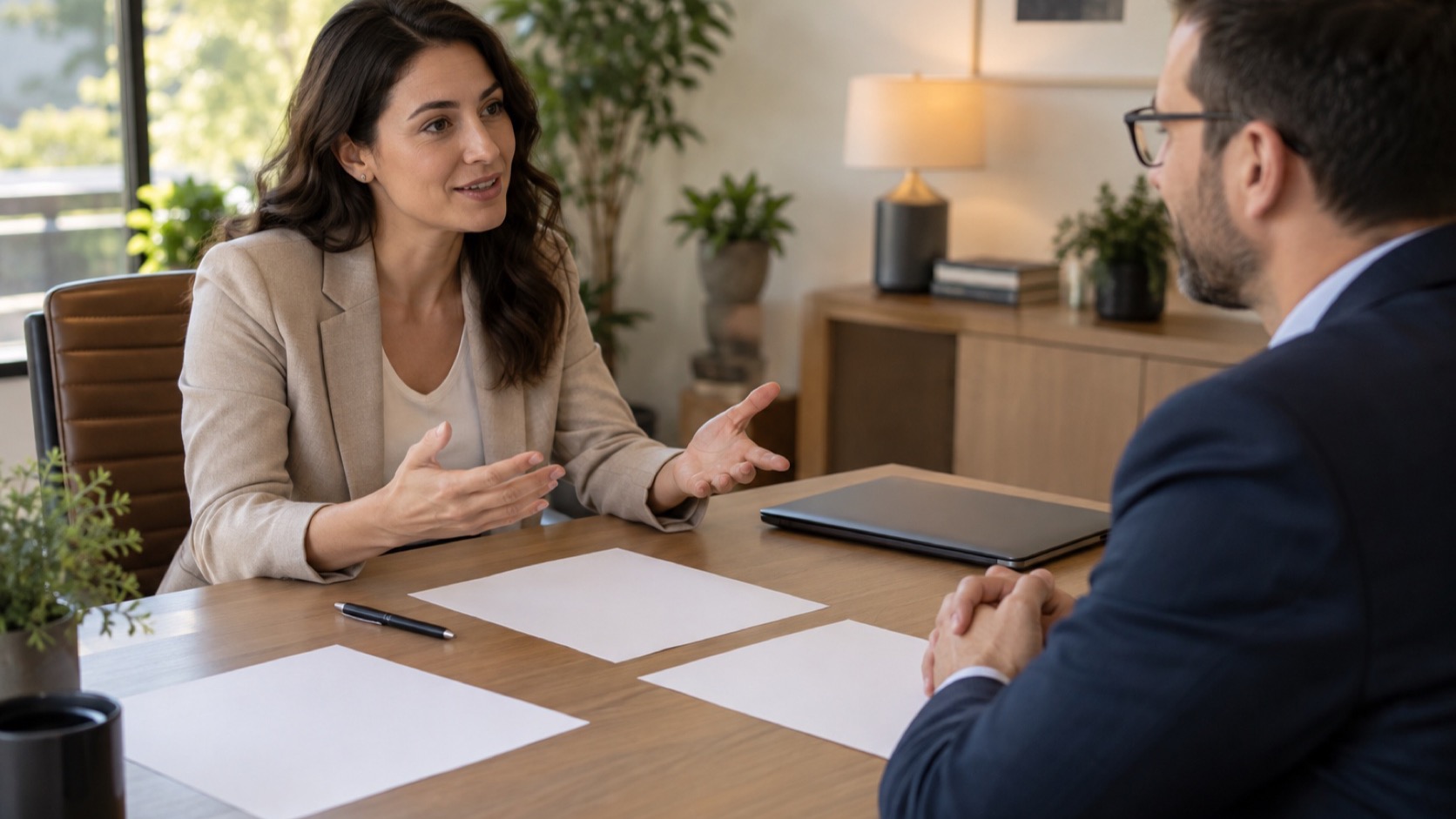 Clinician and adult compare blank papers at desk.